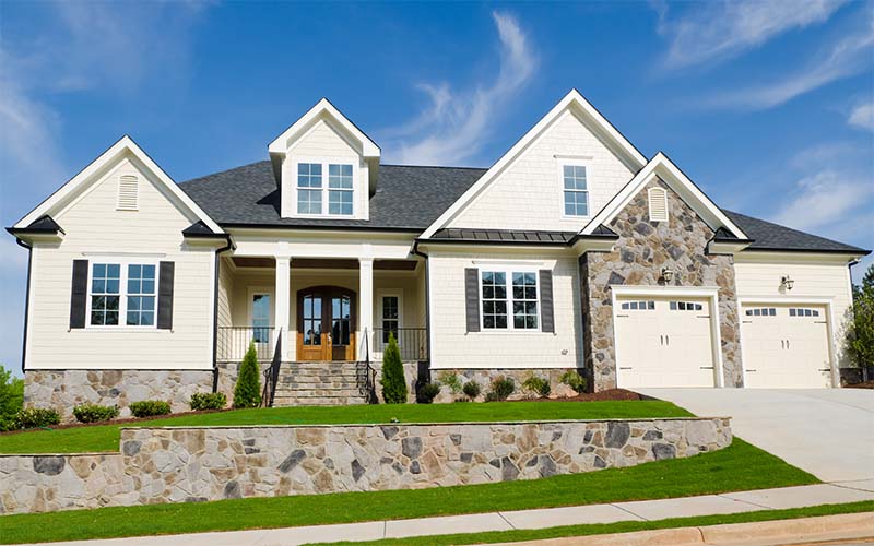 White siding paired with natural stone accents on a suburban home